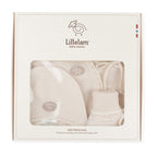 Lillelam 100% merino wool baby gift set in its original cream-colored packaging box, showing a knit hat, bootie, and swaddle blanket through a clear window.
